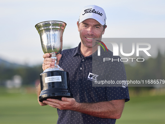 Julien Guerrier of France poses with the trophy on the 18th green following victory in a nine-hole play-off during day four of the Estrella...