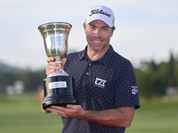 Julien Guerrier of France poses with the trophy on the 18th green following victory in a nine-hole play-off during day four of the Estrella...