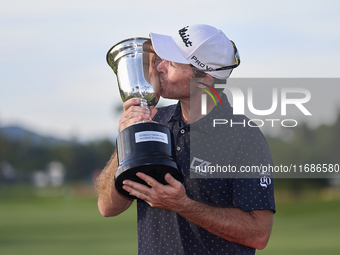 Julien Guerrier of France kisses the trophy on the 18th green following victory in a nine-hole play-off during day four of the Estrella Damm...