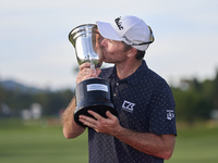 Julien Guerrier of France kisses the trophy on the 18th green following victory in a nine-hole play-off during day four of the Estrella Damm...