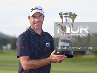 Julien Guerrier of France poses with the trophy on the 18th green following victory in a nine-hole play-off during day four of the Estrella...