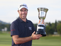 Julien Guerrier of France poses with the trophy on the 18th green following victory in a nine-hole play-off during day four of the Estrella...