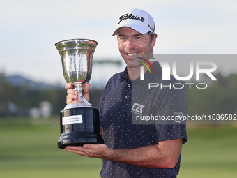 Julien Guerrier of France poses with the trophy on the 18th green following victory in a nine-hole play-off during day four of the Estrella...