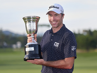 Julien Guerrier of France poses with the trophy on the 18th green following victory in a nine-hole play-off during day four of the Estrella...