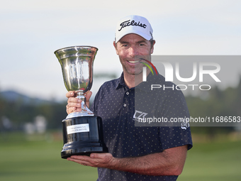 Julien Guerrier of France poses with the trophy on the 18th green following victory in a nine-hole play-off during day four of the Estrella...