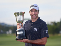 Julien Guerrier of France poses with the trophy on the 18th green following victory in a nine-hole play-off during day four of the Estrella...