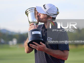 Julien Guerrier of France kisses the trophy on the 18th green following victory in a nine-hole play-off during day four of the Estrella Damm...