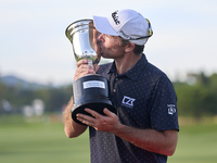 Julien Guerrier of France kisses the trophy on the 18th green following victory in a nine-hole play-off during day four of the Estrella Damm...