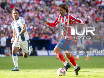 Antoine Griezmann of Atletico de Madrid (R) is in action with the ball during the La Liga EA Sports 2024/25 football match between Atletico...