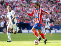 Antoine Griezmann of Atletico de Madrid (R) is in action with the ball during the La Liga EA Sports 2024/25 football match between Atletico...