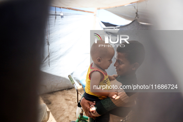 Displaced Palestinian children play outside their tent in a temporary camp in Khan Yunis, Gaza Strip, on October 20, 2024, amid the ongoing...