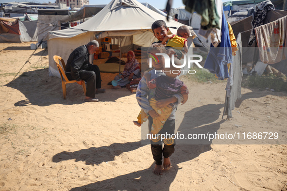 Displaced Palestinian children play outside their tent in a temporary camp in Khan Yunis, Gaza Strip, on October 20, 2024, amid the ongoing...