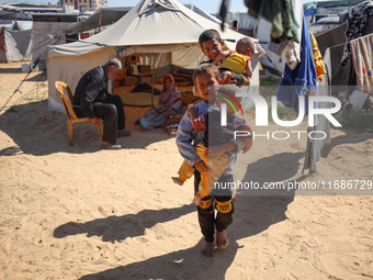 Displaced Palestinian children play outside their tent in a temporary camp in Khan Yunis, Gaza Strip, on October 20, 2024, amid the ongoing...