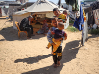 Displaced Palestinian children play outside their tent in a temporary camp in Khan Yunis, Gaza Strip, on October 20, 2024, amid the ongoing...