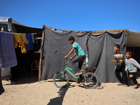 Displaced Palestinian children play outside their tent in a temporary camp in Khan Yunis, Gaza Strip, on October 20, 2024, amid the ongoing...