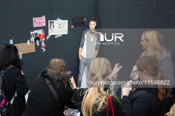 A hundred fans of former One Direction member Liam Payne gather to hold a memorial tribute at Dom Square following the death of the singer i...