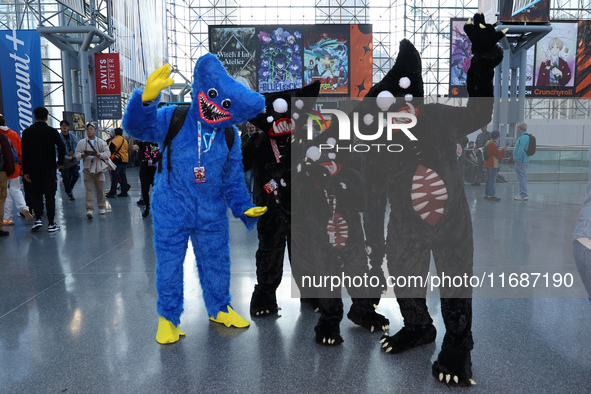 A family dresses as Poppy Playtime, Kelly Willy, and Huggy Wuggy from the video game Poppy Playtime for New York Comic Con at the Javits Cen...