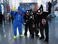 A family dresses as Poppy Playtime, Kelly Willy, and Huggy Wuggy from the video game Poppy Playtime for New York Comic Con at the Javits Cen...