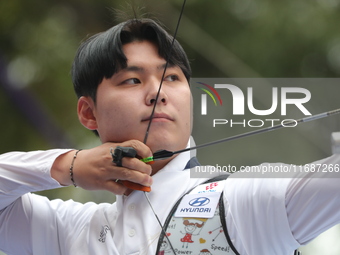 Woo-Seok Lee of Korea competes against Dhiraj Bommadevara of India (not in picture) during the Men's recurve quarterfinals match on the fina...