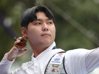 Woo-Seok Lee of Korea competes against Dhiraj Bommadevara of India (not in picture) during the Men's recurve quarterfinals match on the fina...