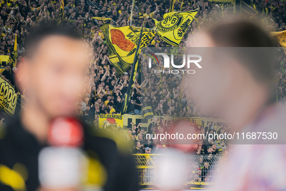 Fans of Borussia Dortmund cheer for their team as Head Coach Nuri Sahin of Borussia Dortmund gives an interview prior to the Bundesliga matc...