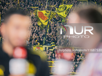 Fans of Borussia Dortmund cheer for their team as Head Coach Nuri Sahin of Borussia Dortmund gives an interview prior to the Bundesliga matc...