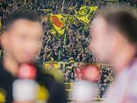 Fans of Borussia Dortmund cheer for their team as Head Coach Nuri Sahin of Borussia Dortmund gives an interview prior to the Bundesliga matc...