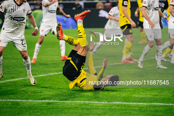 Ramy Bensebaini of Borussia Dortmund falls down during the Bundesliga match between Borussia Dortmund and FC St. Pauli 1910 at Signal Iduna...