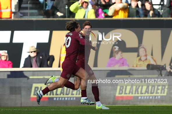 John Stones of Manchester City celebrates with Jack Grealish after scoring his side's second goal during the Premier League match between Wo...