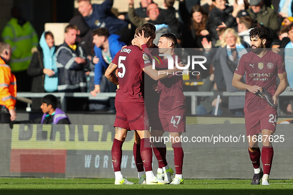 John Stones of Manchester City celebrates with Phil Foden after scoring his side's second goal during the Premier League match between Wolve...