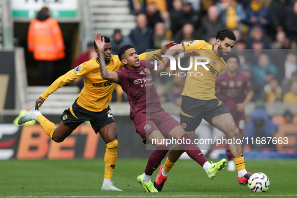 Savinho of Manchester City is in action with Nelson Semedo and Rayan Ait-Nouri of Wolves during the Premier League match between Wolverhampt...