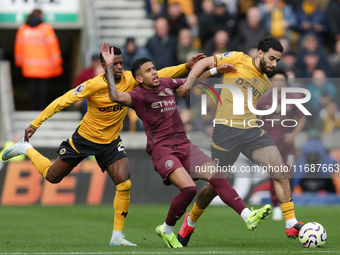 Savinho of Manchester City is in action with Nelson Semedo and Rayan Ait-Nouri of Wolves during the Premier League match between Wolverhampt...