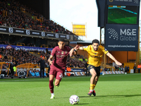 Savinho of Manchester City (L) is in action with Rayan Ait-Nouri of Wolves during the Premier League match between Wolverhampton Wanderers a...