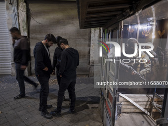 Iranian youths stand together outside a gaming venue at night in Tabriz, Iran, on October 18, 2024, amid global concerns about war between I...