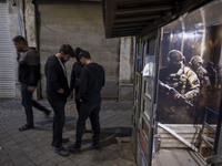 Iranian youths stand together outside a gaming venue at night in Tabriz, Iran, on October 18, 2024, amid global concerns about war between I...