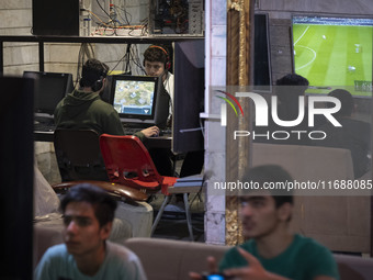 Iranian youths play video games at a gaming venue at night in Tabriz, Iran, on October 18, 2024, amid global concerns about war between Iran...