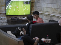 Iranian youths play FIFA at a gaming venue at night in the historical city of Tabriz, Iran, on October 18, 2024, amid global concerns about...