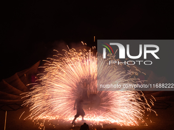 A Zoolians artist captivates the audience with a fiery performance during the closing show of '????????'?????: Arcanes' in the Arles arenas....