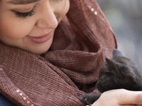 A young Iranian woman hugs a cat while sitting at a historical bazaar in Tabriz, Iran, on October 17, 2024, amid global concerns about war b...