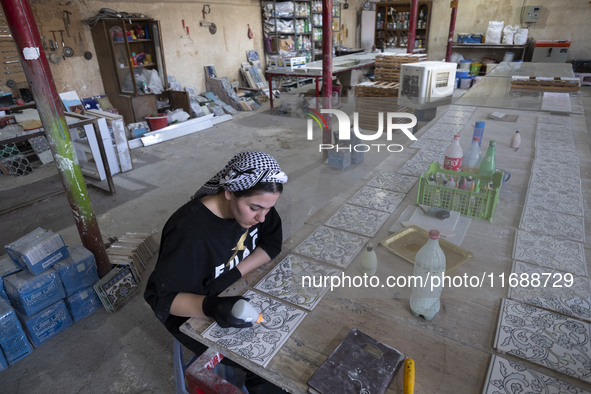 A young Iranian woman works at a ceramic tile workshop in the suburb of the historical city of Tabriz, Iran, on October 19, 2024, amid globa...