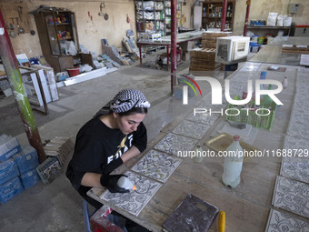 A young Iranian woman works at a ceramic tile workshop in the suburb of the historical city of Tabriz, Iran, on October 19, 2024, amid globa...