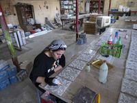 A young Iranian woman works at a ceramic tile workshop in the suburb of the historical city of Tabriz, Iran, on October 19, 2024, amid globa...