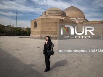 A young Iranian woman poses for a photograph while visiting the historical Blue Mosque in Tabriz, Iran, on October 16, 2024, amid global con...