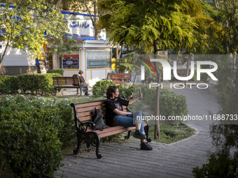 A young Iranian woman takes a selfie while sitting on a bench in the historical city of Tabriz, located 624 km (388 miles) northwest of Tehr...