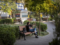 A young Iranian woman takes a selfie while sitting on a bench in the historical city of Tabriz, located 624 km (388 miles) northwest of Tehr...