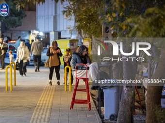 A young Iranian woman sits at an outdoor cafe at night in the historical city of Tabriz, Iran, on October 17, 2024, amid global concerns abo...