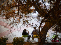 Two Iranian men sit together on a sidewalk at night in the historical city of Tabriz, Iran, on October 16, 2024, amid global concerns about...