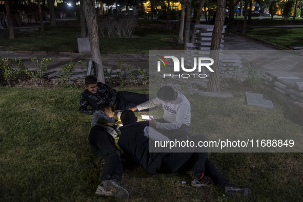 Iranian youths lie down at a park at night in the historical city of Tabriz, Iran, on October 16, 2024, amid global concerns about war betwe...