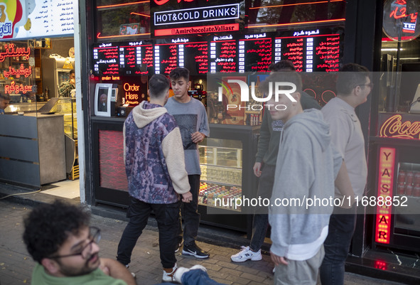 A group of young men stands together outside a fast-food restaurant in Tabriz, Iran, on October 17, 2024, amid global concerns about war bet...