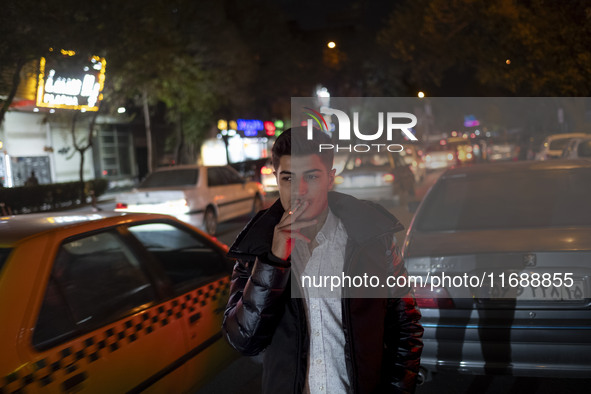 A Turkish tourist smokes a cigarette while standing on a street at night in the historical city of Tabriz, Iran, on October 18, 2024, amid g...